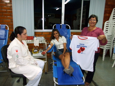 A Sra. Veralice mostra a camisa da camapanha enquanto a aluna faz a doa&ccedil;&atilde;o