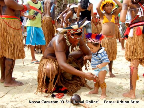 O &iacute;ndiozinho Raiua&atilde; (Eclipse) de oito meses de vida sendo vestido a c&aacute;rater pelo papai para participar dos jogos