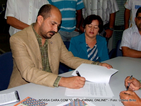 O prefeito Rob&eacute;rio Oliveira junto com a vice-prefeita Maria Menezes assinam o conv&ecirc;nio para a constru&ccedil;&atilde;o de 1.500 casas 