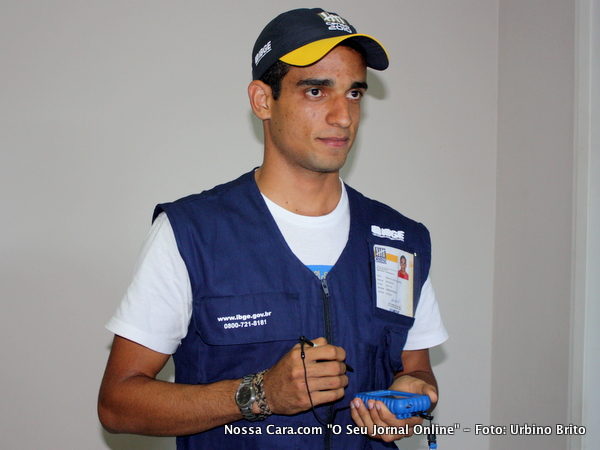 Recenseador devidamente paramentado com o colete com seus dados cadastrais do lado esquerdo e acima do bolso direito um telefone 0800 para se tirar qualquer duvida al&eacute;m de um PDA na cor azul