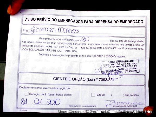 Um dos funcion&aacute;rios exibe o formul&aacute;rio do aviso pr&eacute;vio para a nossa lente