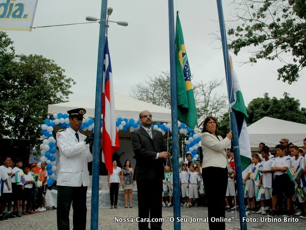 Momento em que as autoridades fazem o hasteamento das bandeira, o tenente Josari Coutinho (Bandeira da Bahia), o prefeito Rob&eacute;rio Oliveira (Bandeira do Brasil) e a vereadora Carm&eacute;m L&uacute;cia (Bandeira de Eun&aacute;polis)