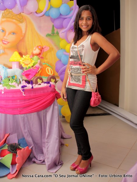 Mariana Bahia menina mo&ccedil;a um bot&atilde;o de flor que come&ccedil;a a desabrochar