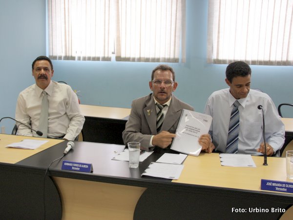 Ladeado pelo vereadores Am&oacute;s e Z&eacute; Miranda, Normando aponta para um exemplar do or&ccedil;amento 2011 que come&ccedil;a a tramitar na C&acirc;mara