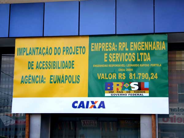Placa com o or&ccedil;amento da obra e o nome da construtora afixada na frente da ag&ecirc;ncia