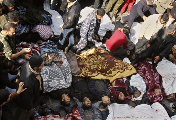 Palestinos andam entre corpos de integrantes do grupo Hamas mortos por ataques de m&iacute;sseis israelenses em Gaza - Fotos: Adel Hana/AP