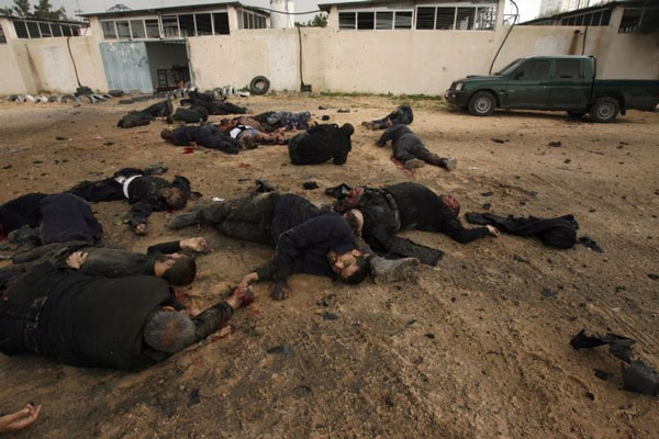 Corpos de palestinos mortos do lado de fora do escrit&oacute;ro de seguran&ccedil;a do grupo isl&acirc;mico Hamas, um dos alvos do ataque a&eacute;reo com m&iacute;sseis feitos por Israel contra a Faixa de Gaza - Fotos: Mohammed Abded/AFP