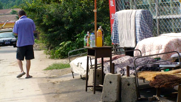 Campon&ecirc;s passa em frente de loja com camas do lado de fora, onde os trabalhadores descansam na hora de almo&ccedil;o - Rodrigo Bertolotto/UOL